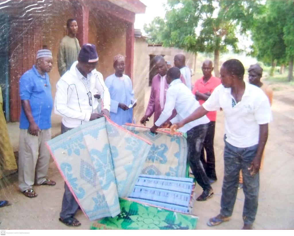 Community members receiving sleeping mats and blankets from the Yaknan team